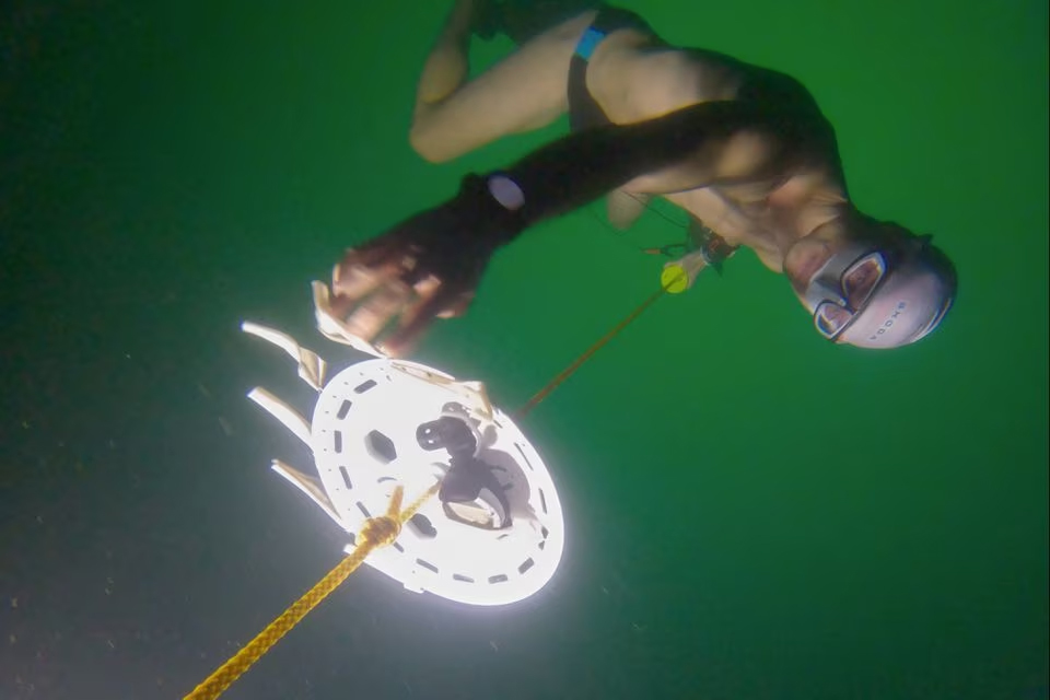 Buceador se sumerge bajo un lago congelado